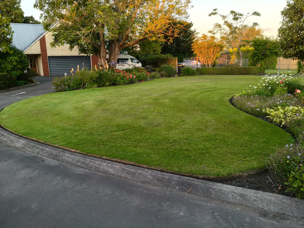 A circular front lawn mowed and edged around a driveway in Christchurch